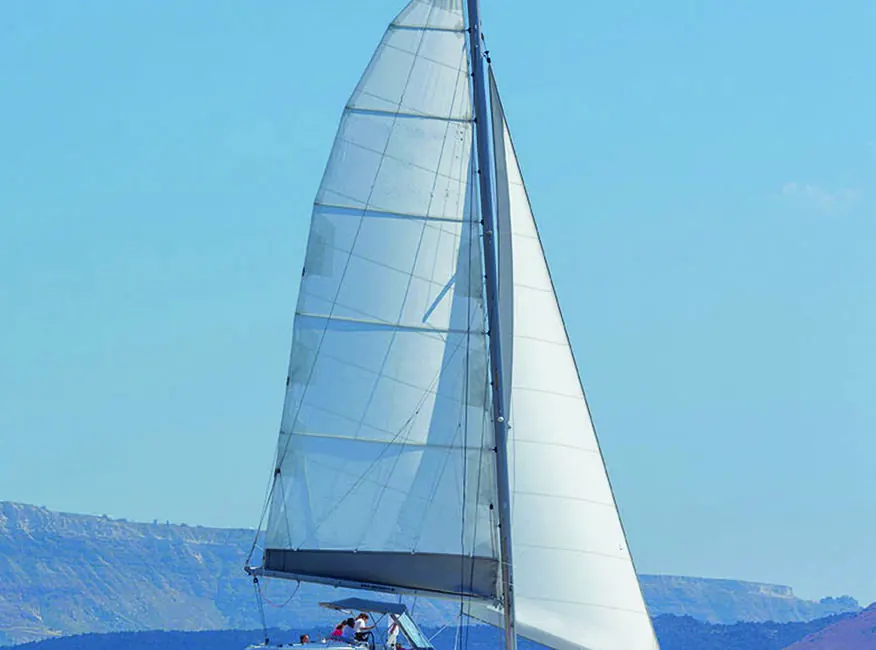 The Sirigos Sailing Lagoon catamaran under full sail in the Santorini caldera