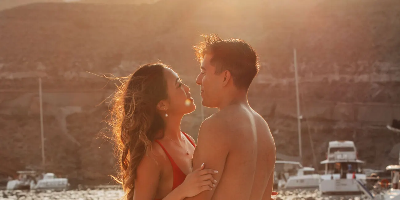 A couple at sunset on the deck of our catamaran in Santorini