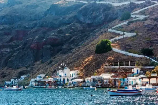 The little harbor of Thirasia island with fishing boats below the cliff path